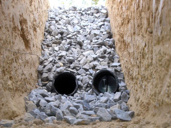 High-capacity French drain installation in Orlando using smooth-interior dual-wall pipe and washed drainage stone.